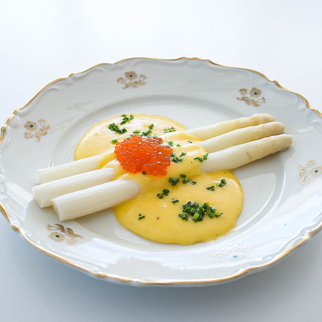 Vit sparris med hollandaisesås, regnbågsrom och gräslök är välsmakande förrätt.